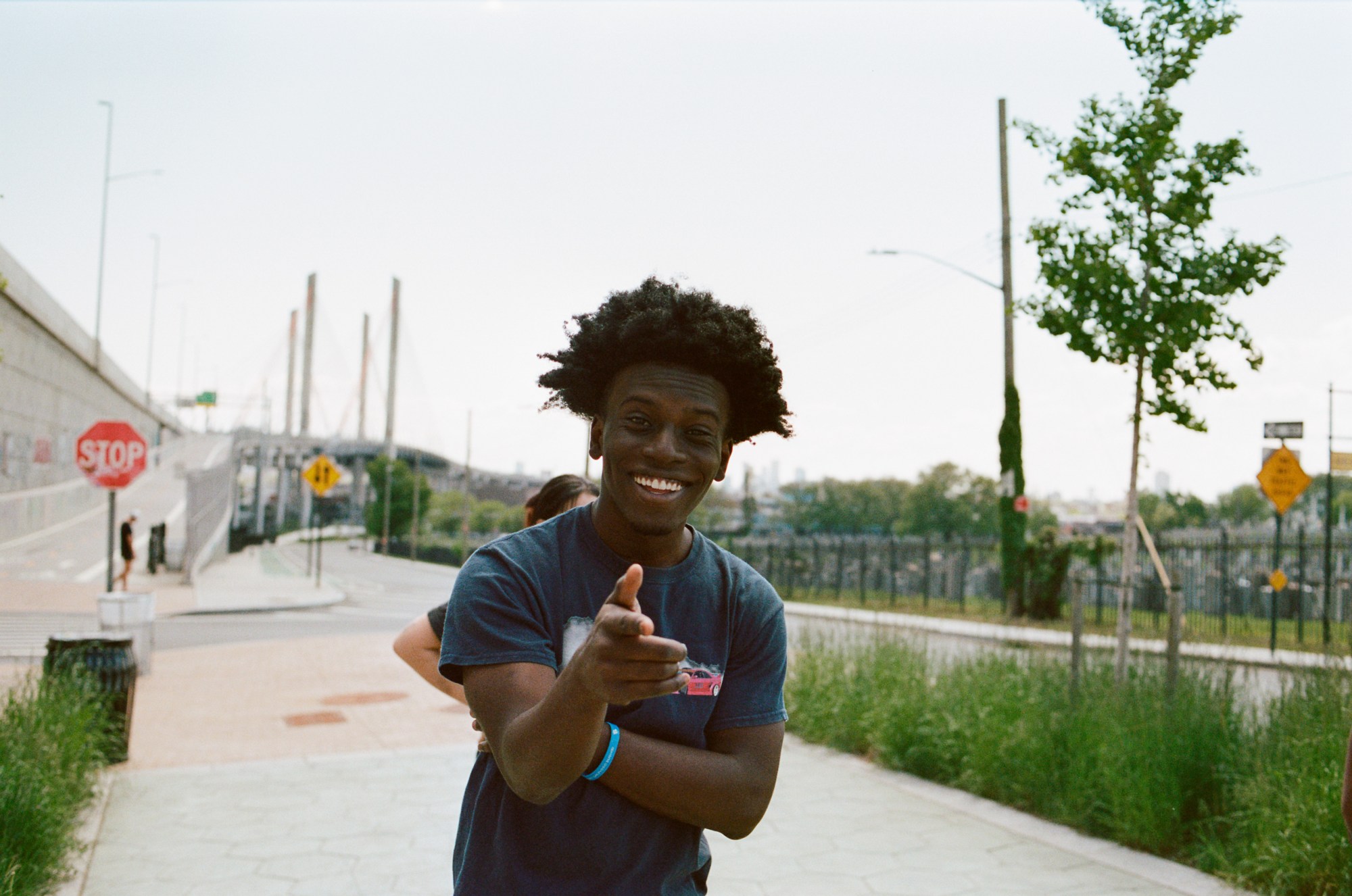 a young man points at the camera and smiles