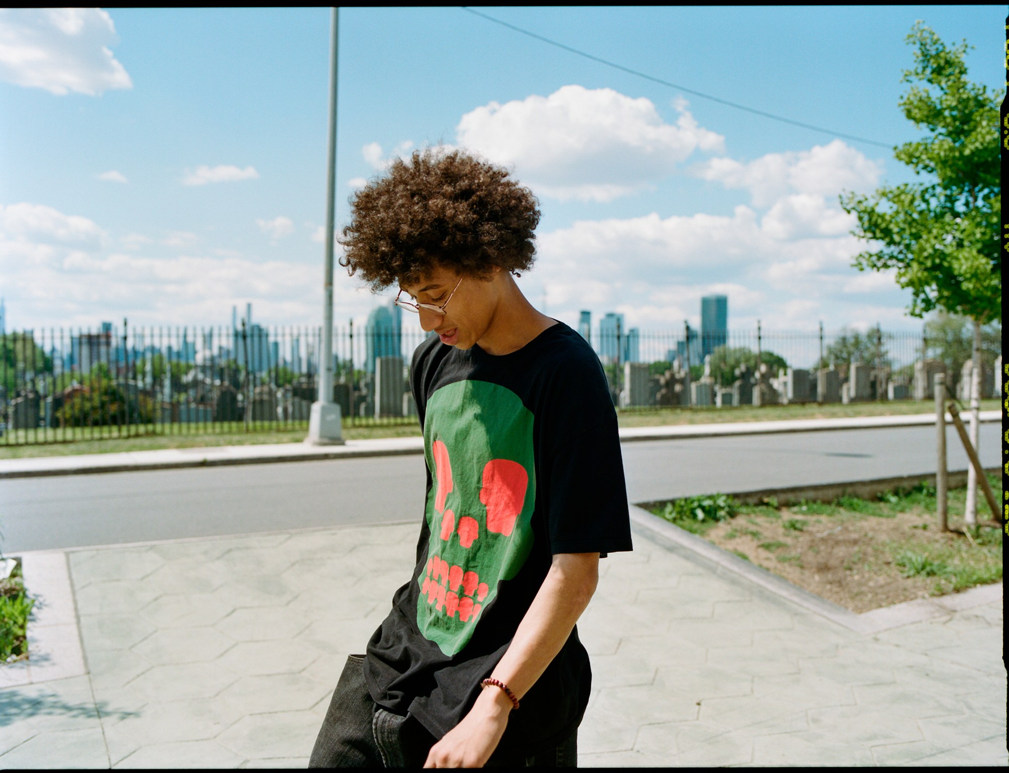 a young man skates with a graveyard visible in the background