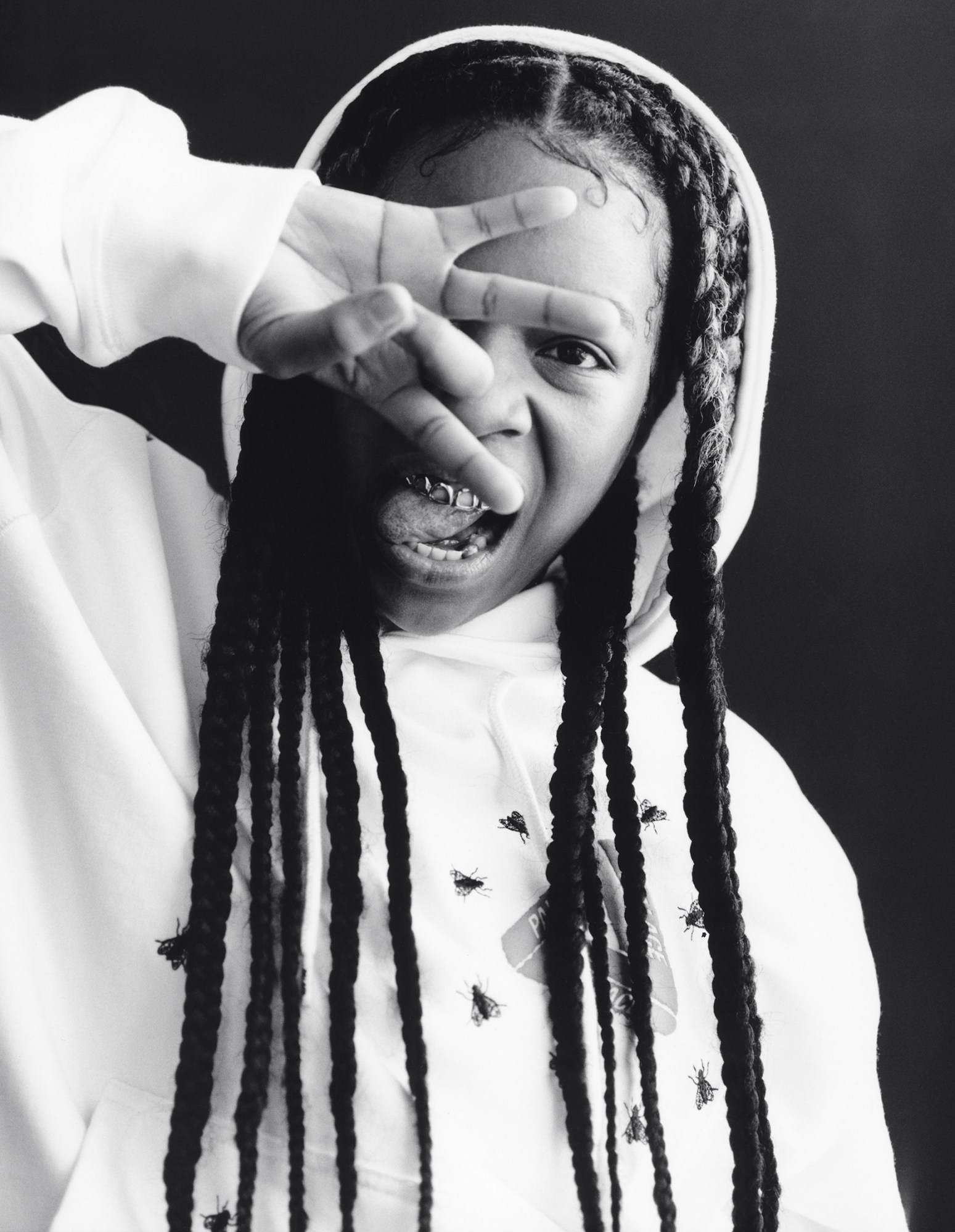 a black-and-white portrait of UK musician Scuti holding her hand in front of her face