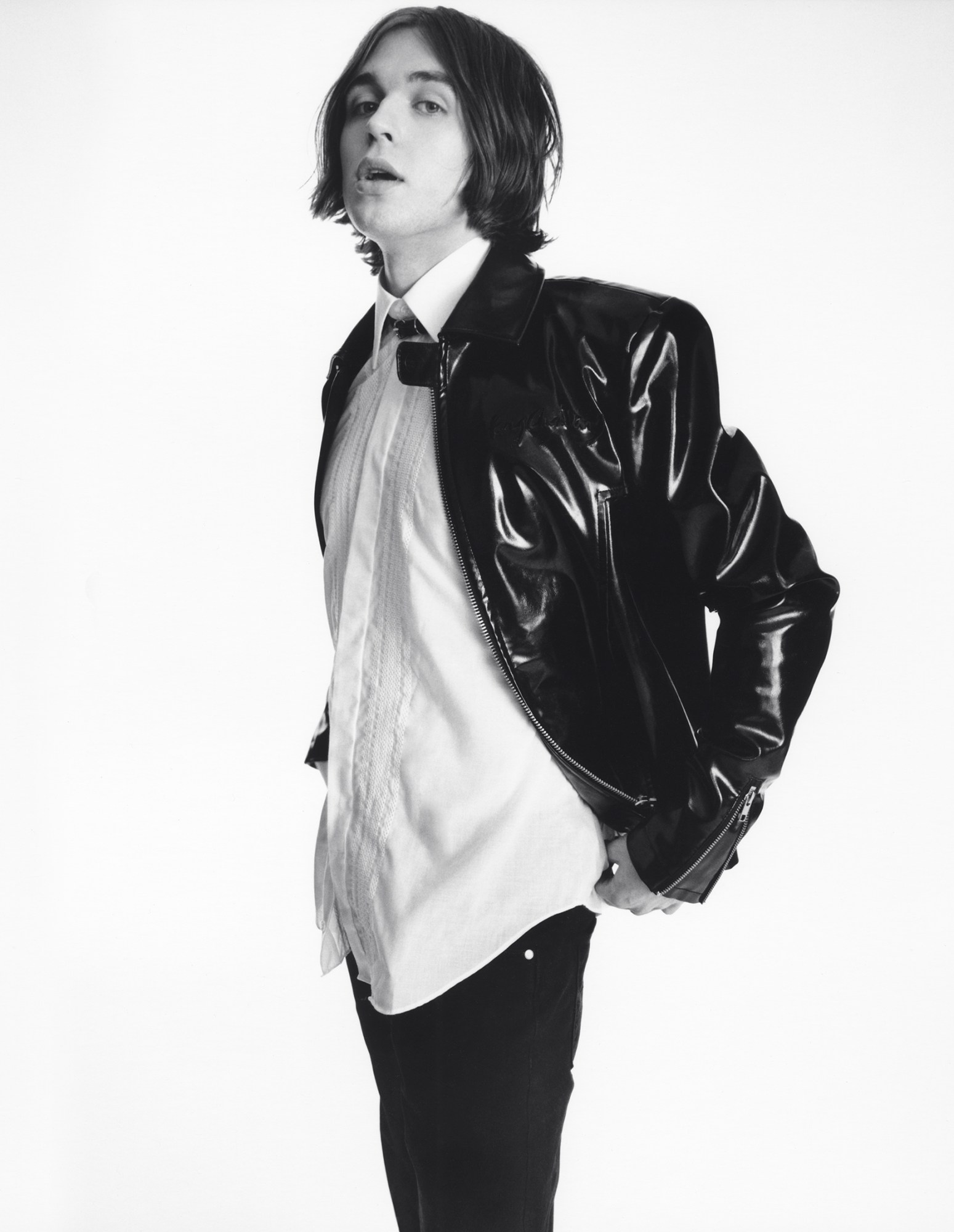 a black-and-white portrait of Olli Appleyard from the band Static Dress wearing a leather jacket over a white shirt