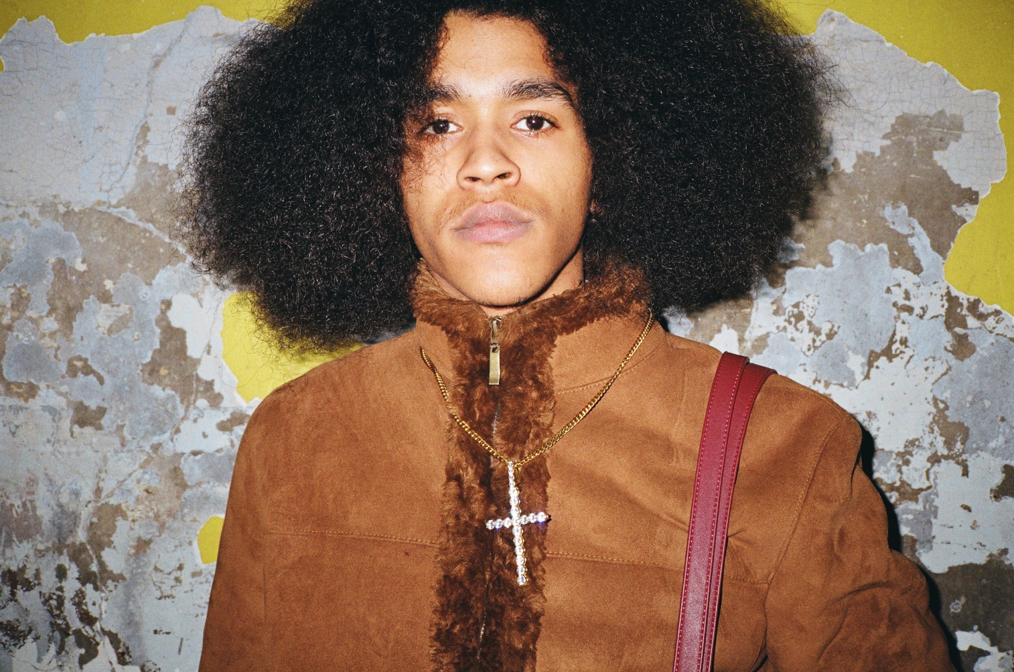 a man with an afro and a cross neckace