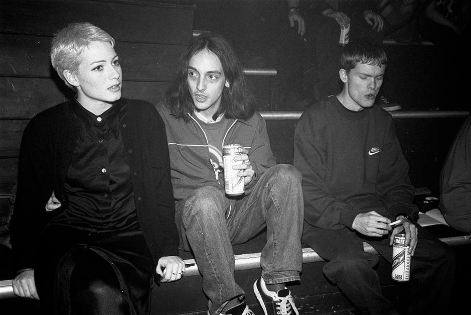 three people sat on steps outside a club