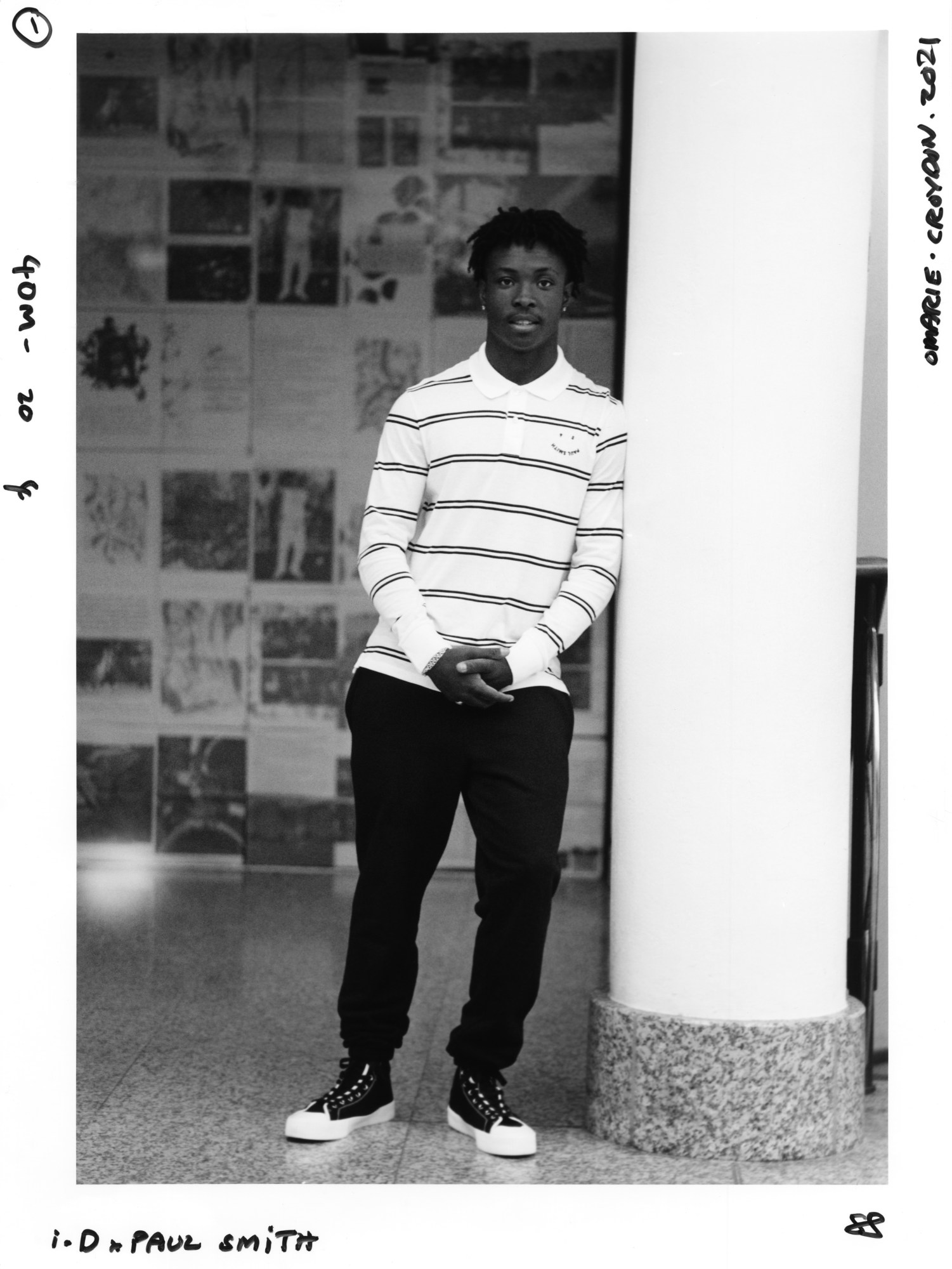 a young man wearing ps by paul smith leans against a pillar