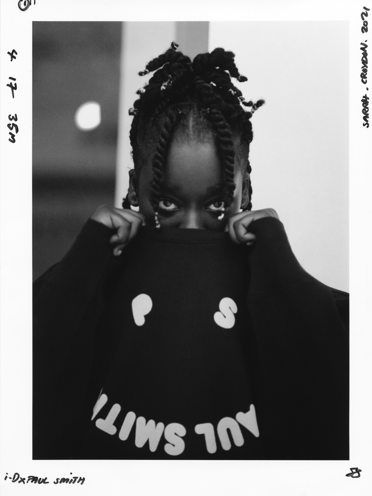 a young woman wearing ps paul smith covers up her face with a jumper