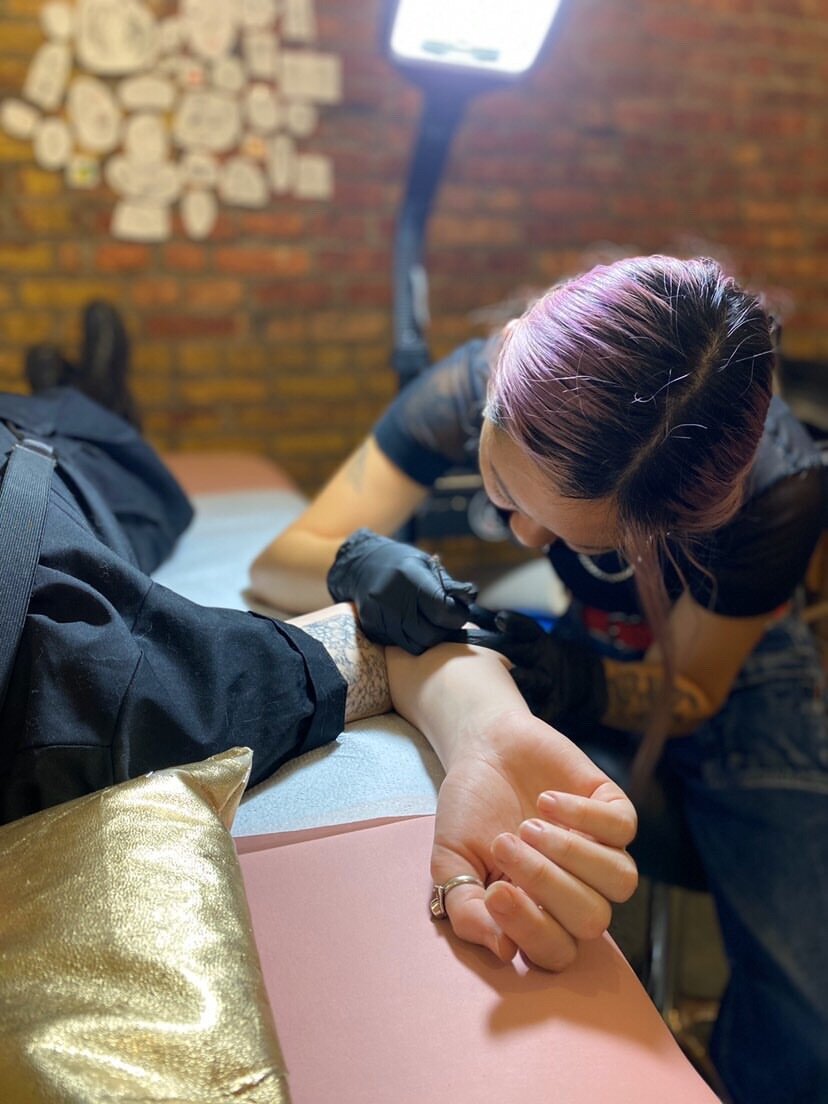 a tattoo artist giving a client a tattoo