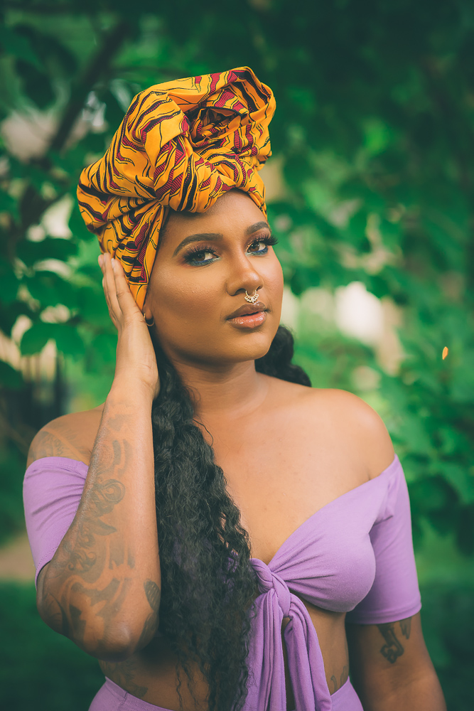 portrait of a krissy the butcher in a hair wrap with her hand on her cheek