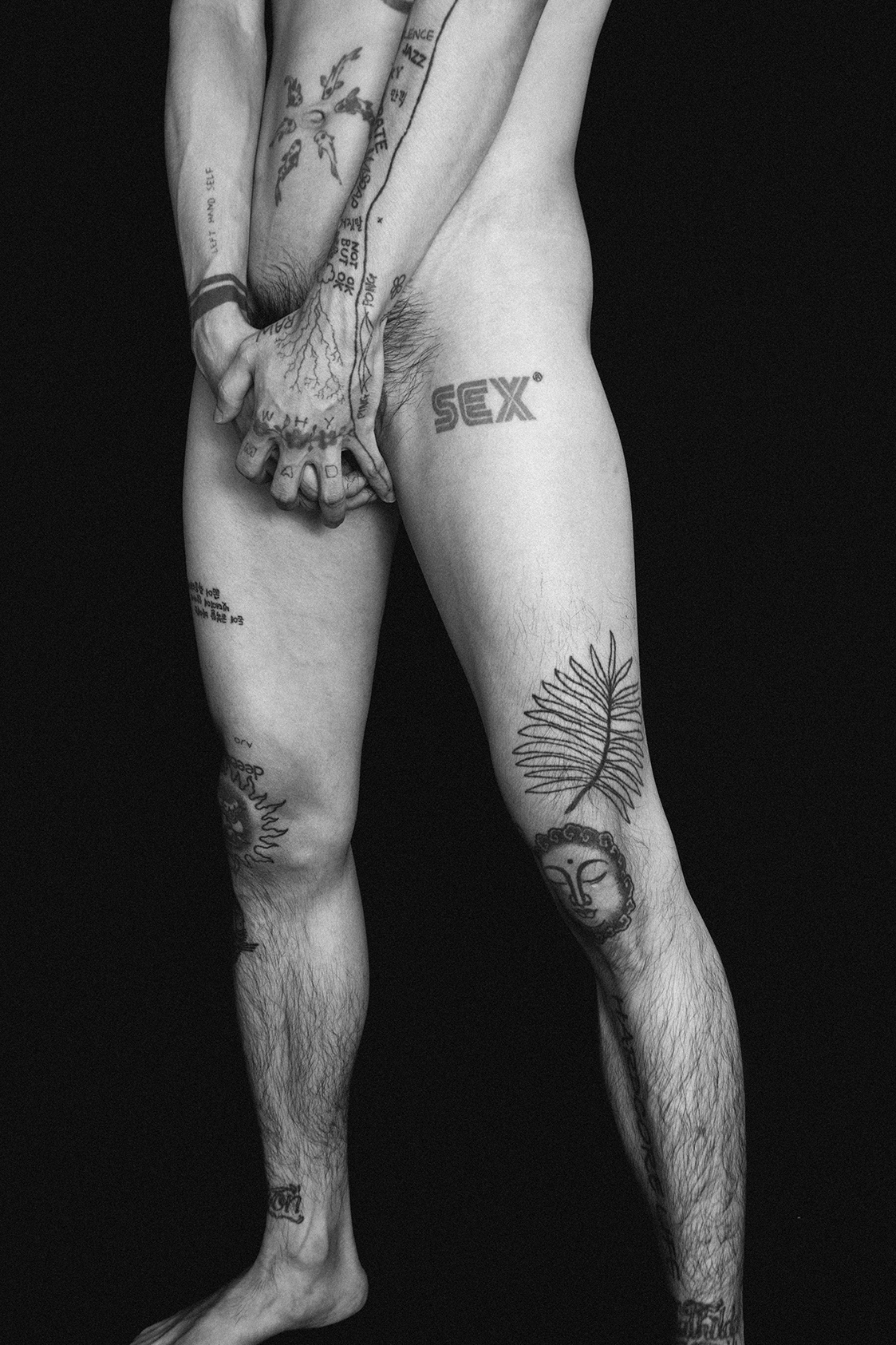 a naked man covered in tattoos from the torso downwards