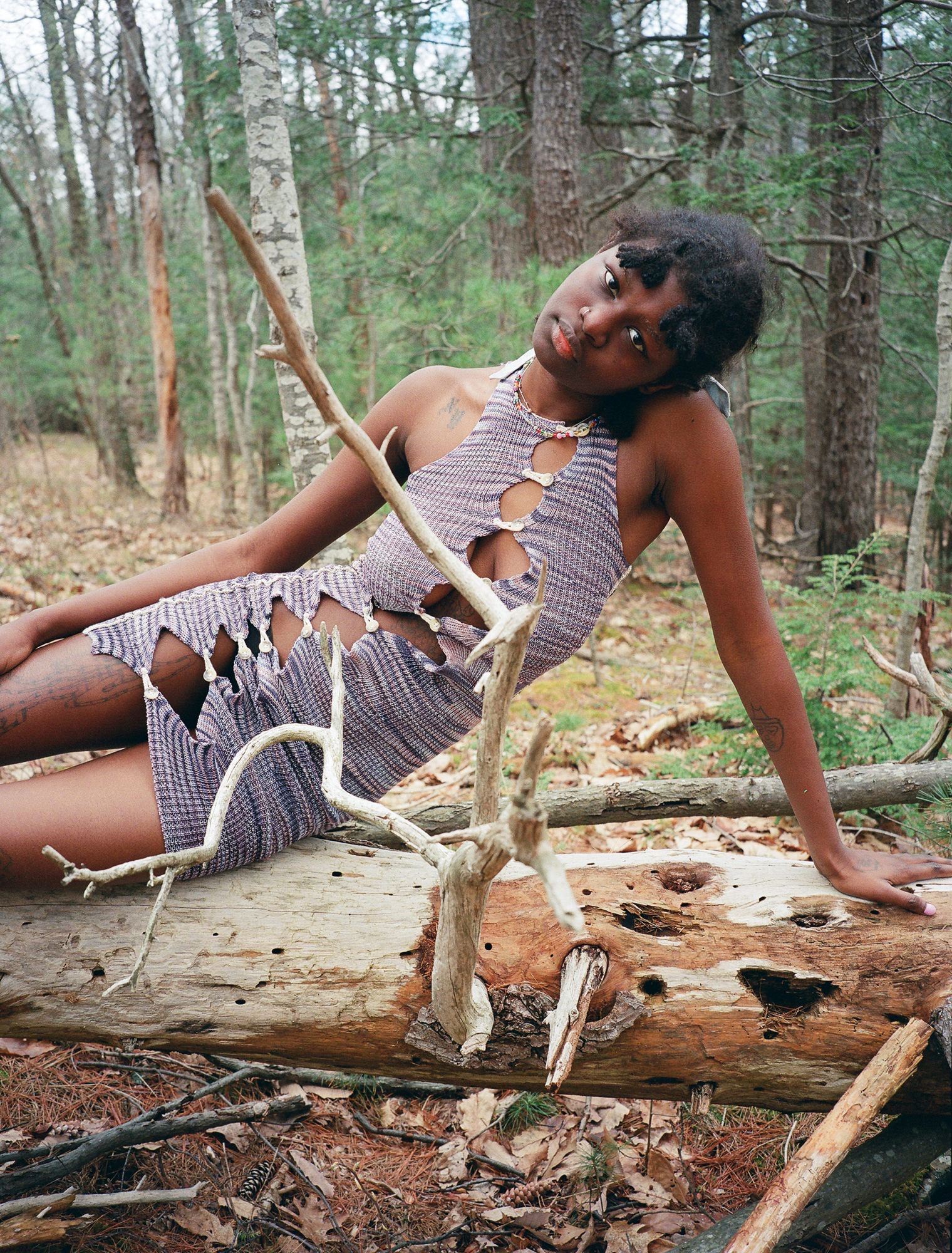 a model posing in the woods wearing sexy knitwear by gabe gordon