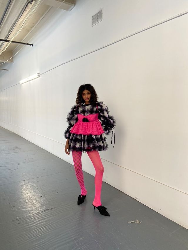 a model posing in a hallway wearing sexy knitwear by crandall duffy