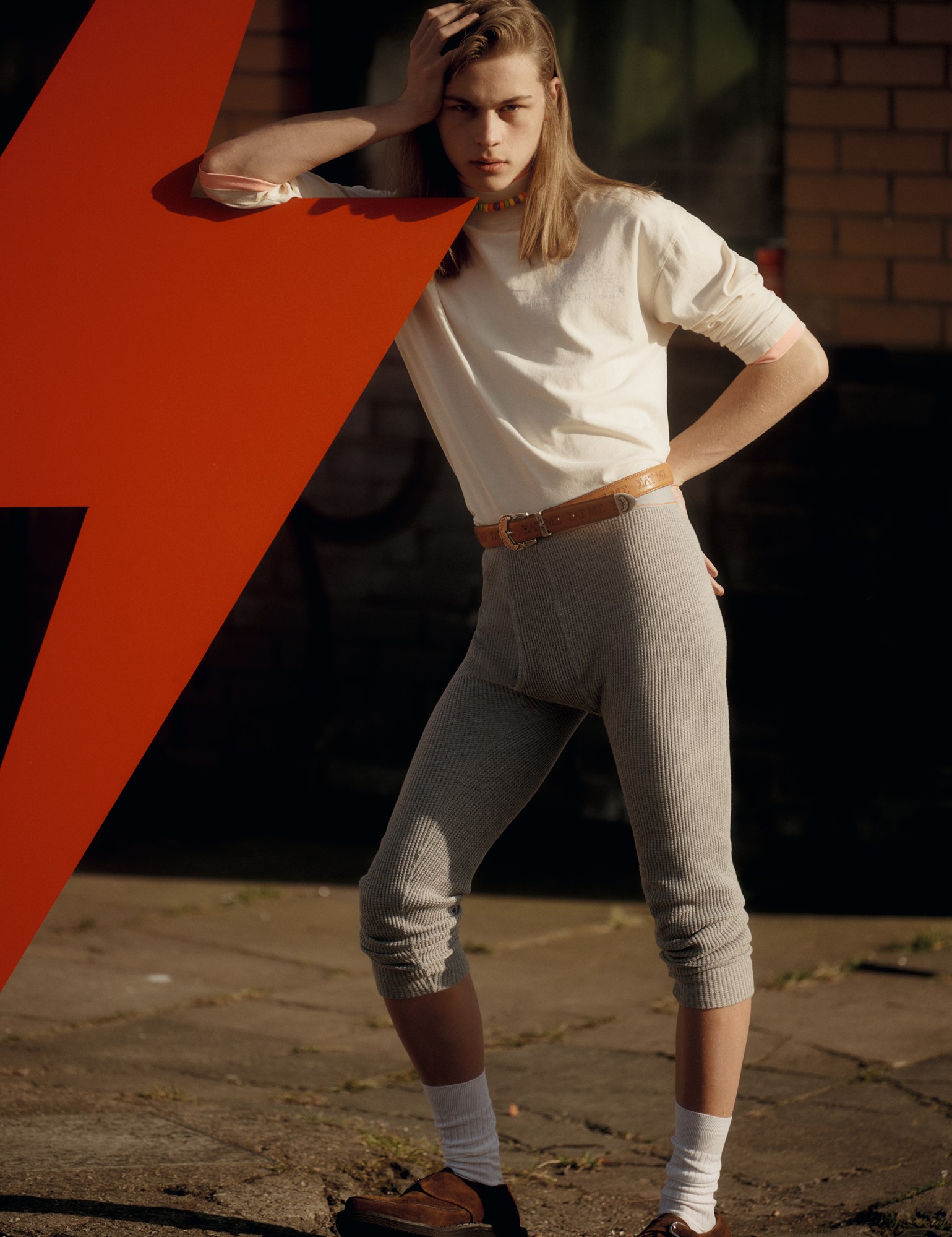 a model wearing beige belted jodhpurs with a white longsleeved t-shirt