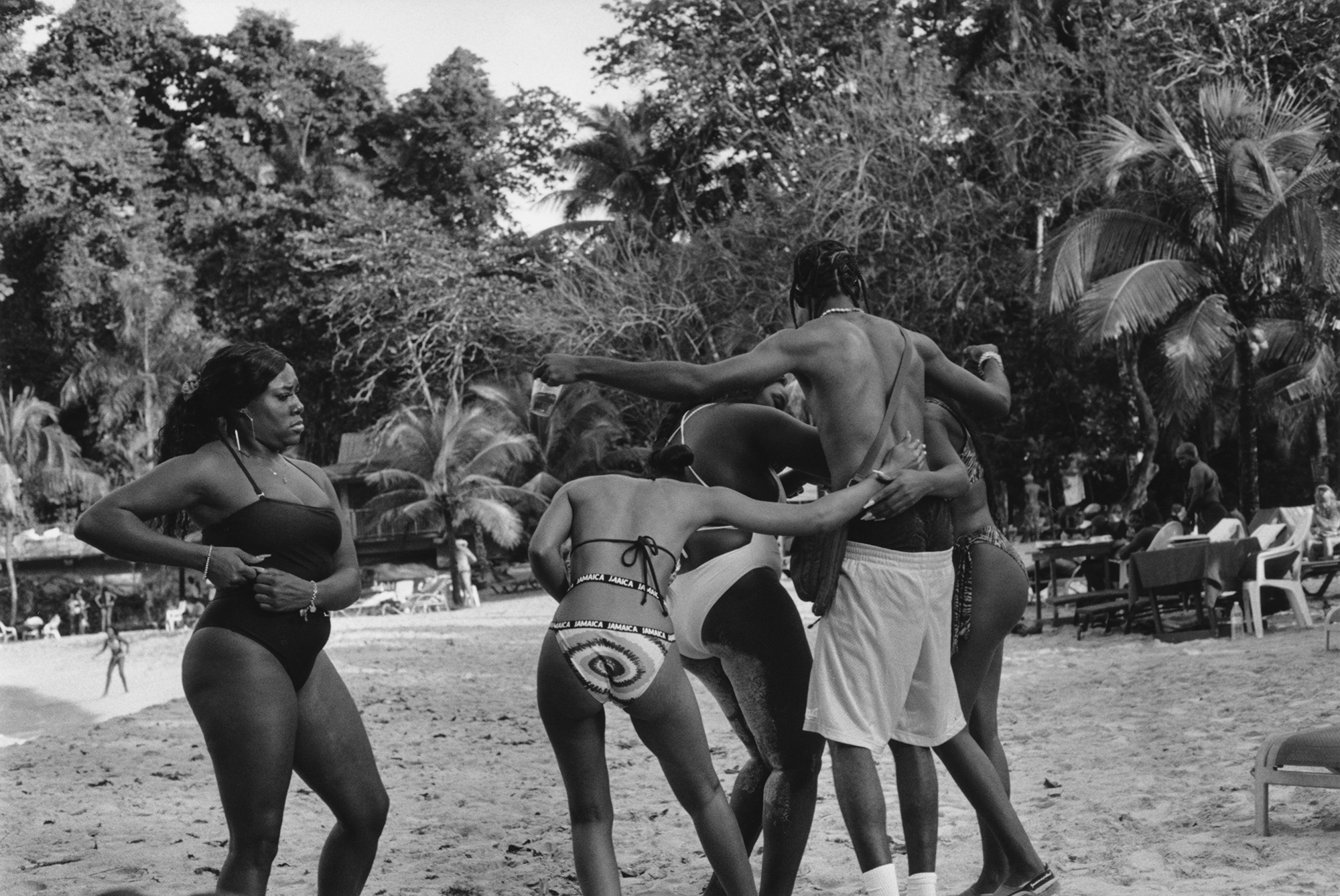 a group of women and one man play around on a beach