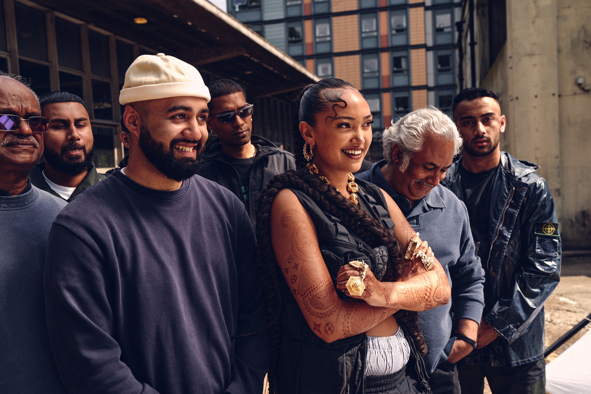 the singer joy crookes and a crew of men watching something happen out of frame on the set of a music video