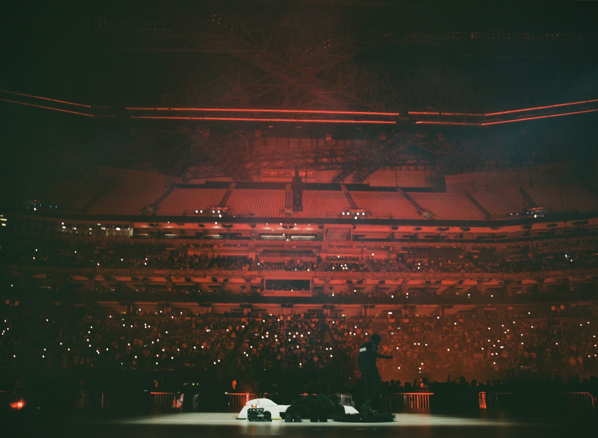 kanye west at his donda playback with the crowd behind him