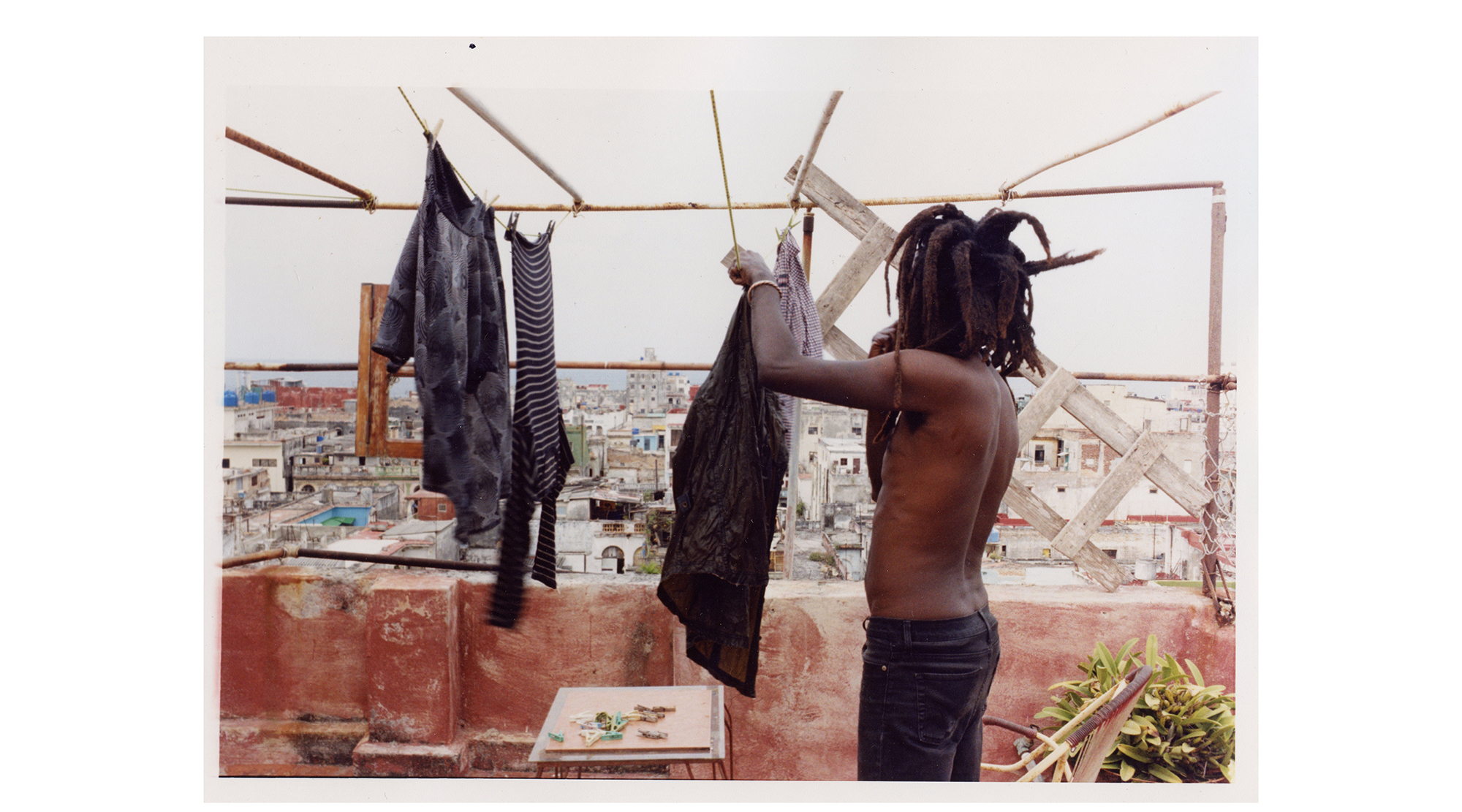 a man hangs out his washing on a rooftop overlooking mexico city