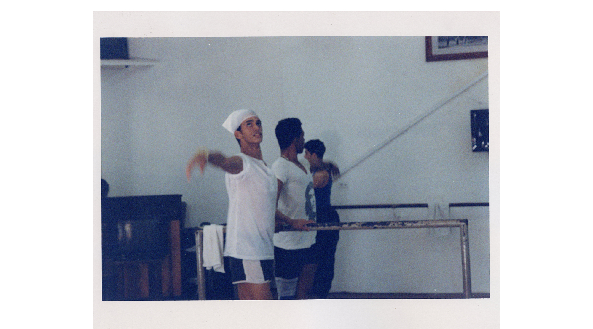 three dancers rehearse at a barre