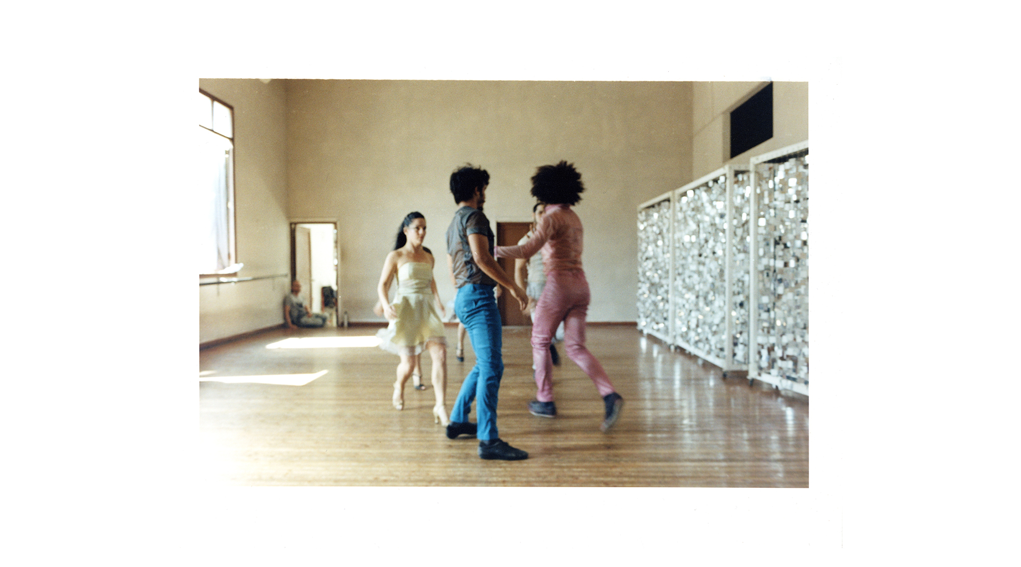 five dancers in colourful clothes dance in a sunny studio