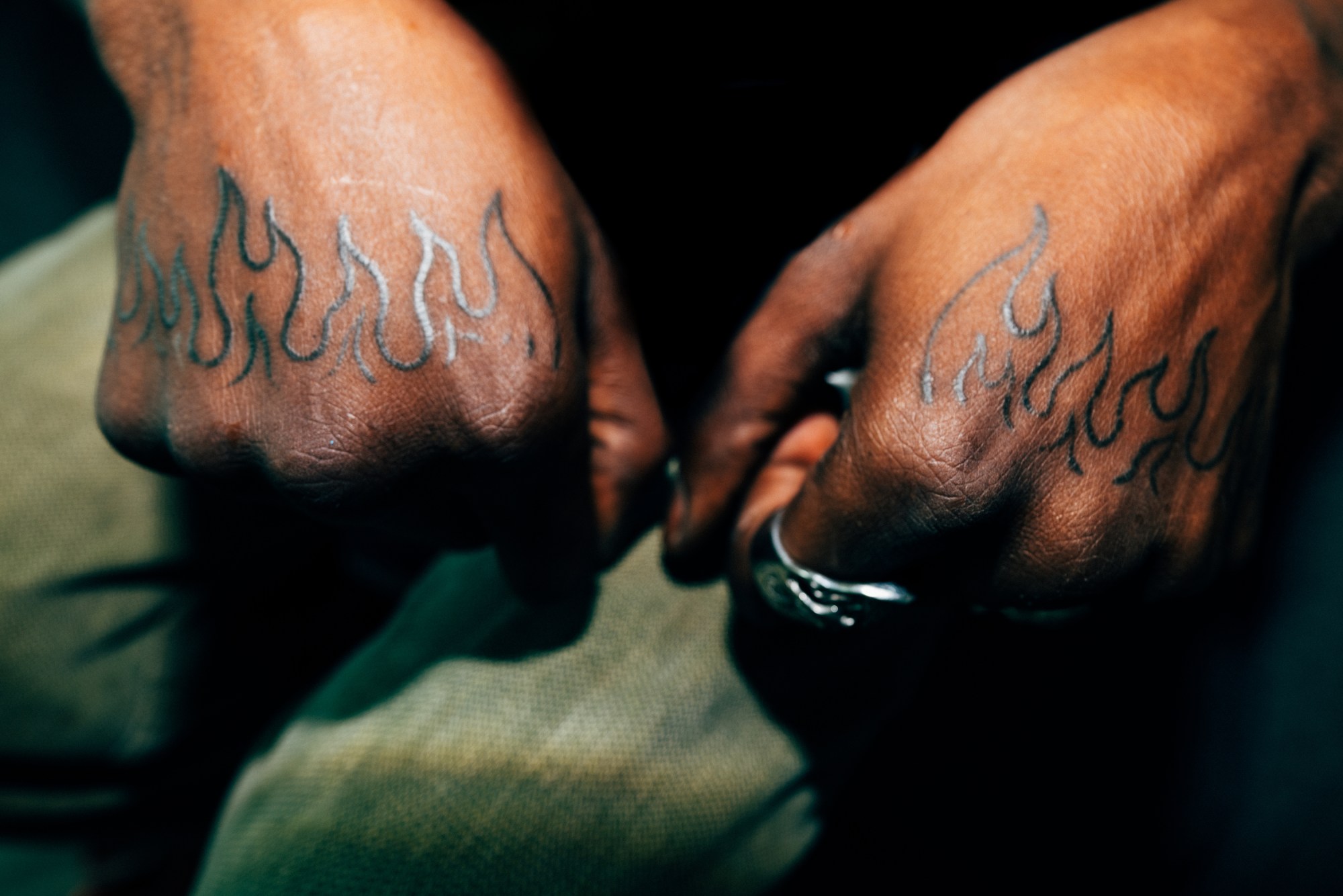 a photo of two hands with flames tattooed on them by blake lewis