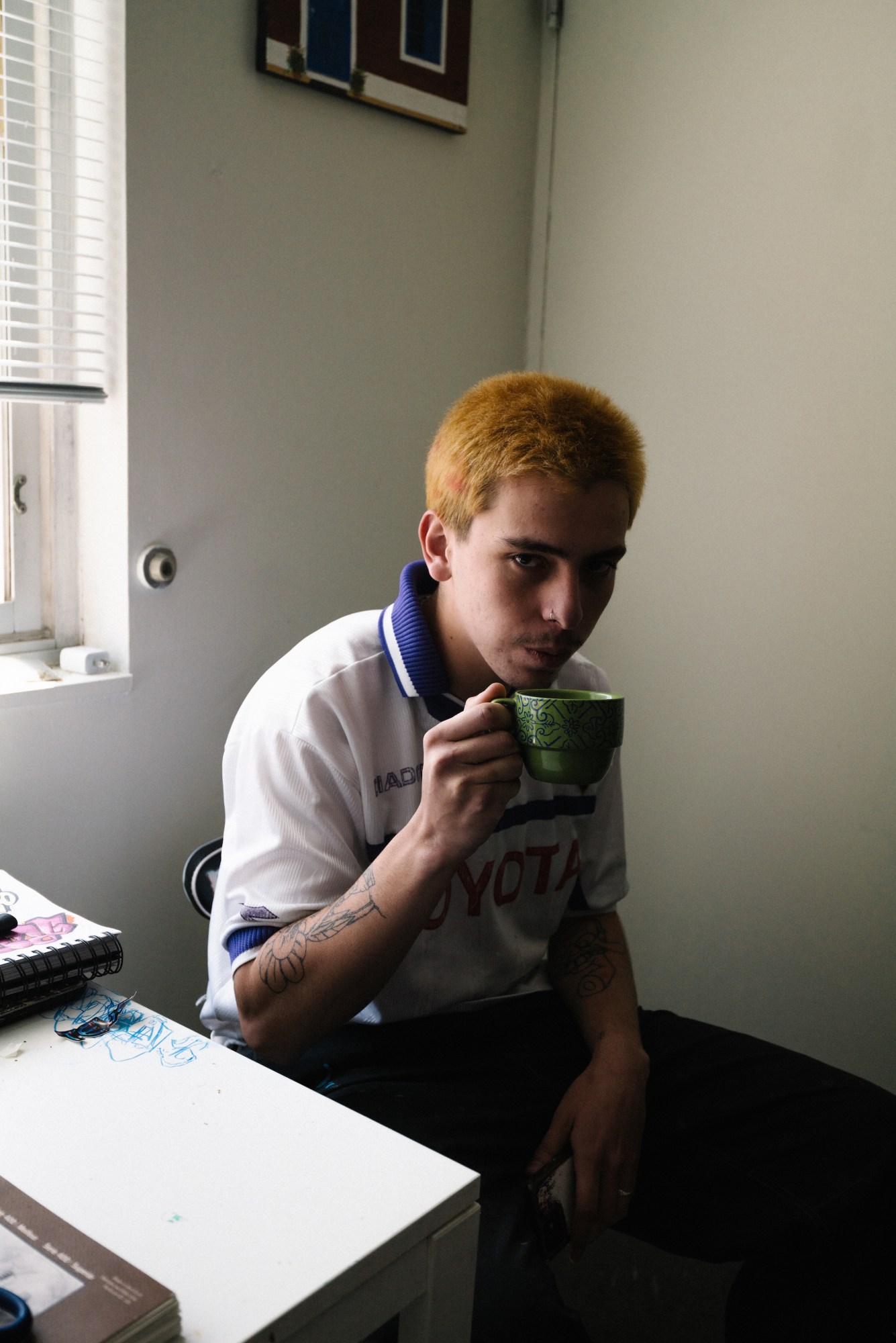 mario cartes sitting in a chair and holding a coffee cup by blake lewis