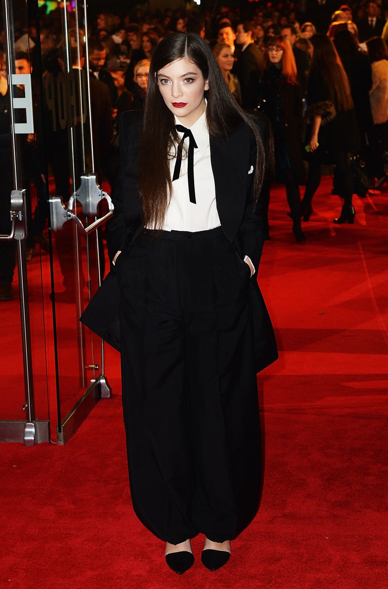 lorde posing on the red carpet with her hands in her pockets 2014