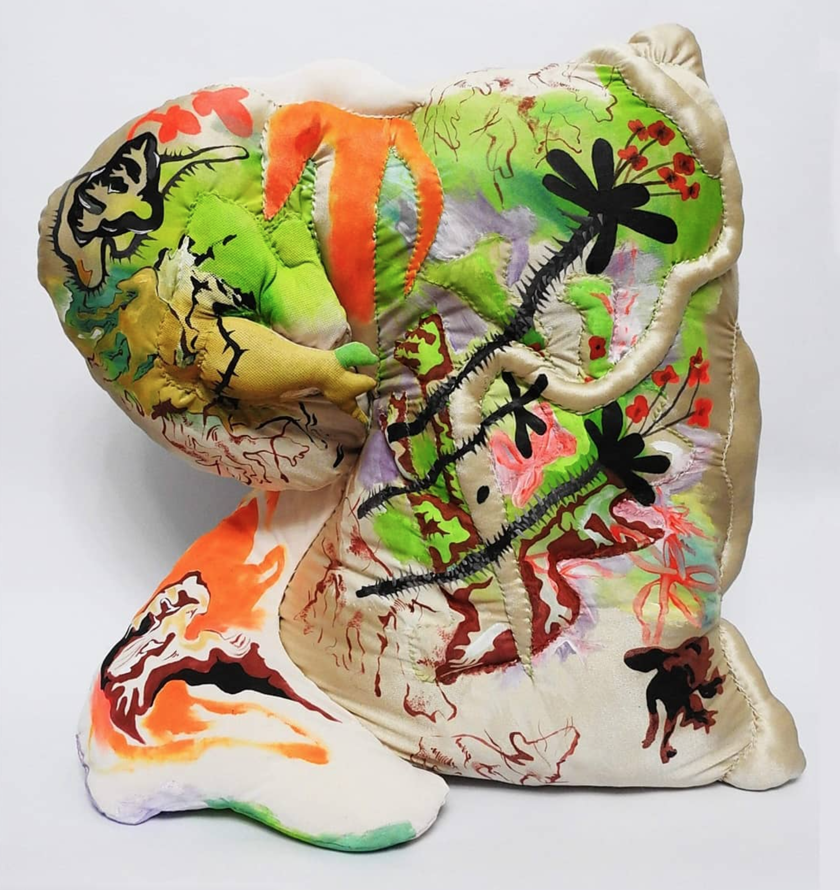 a silk cushion-like structure with apendages and colourful plantlife paintings on it