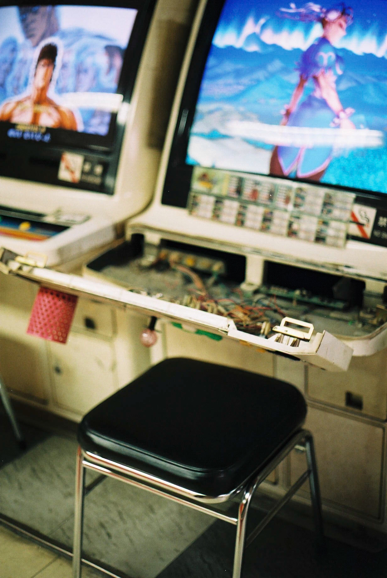 a stool in front of a broken arcade game