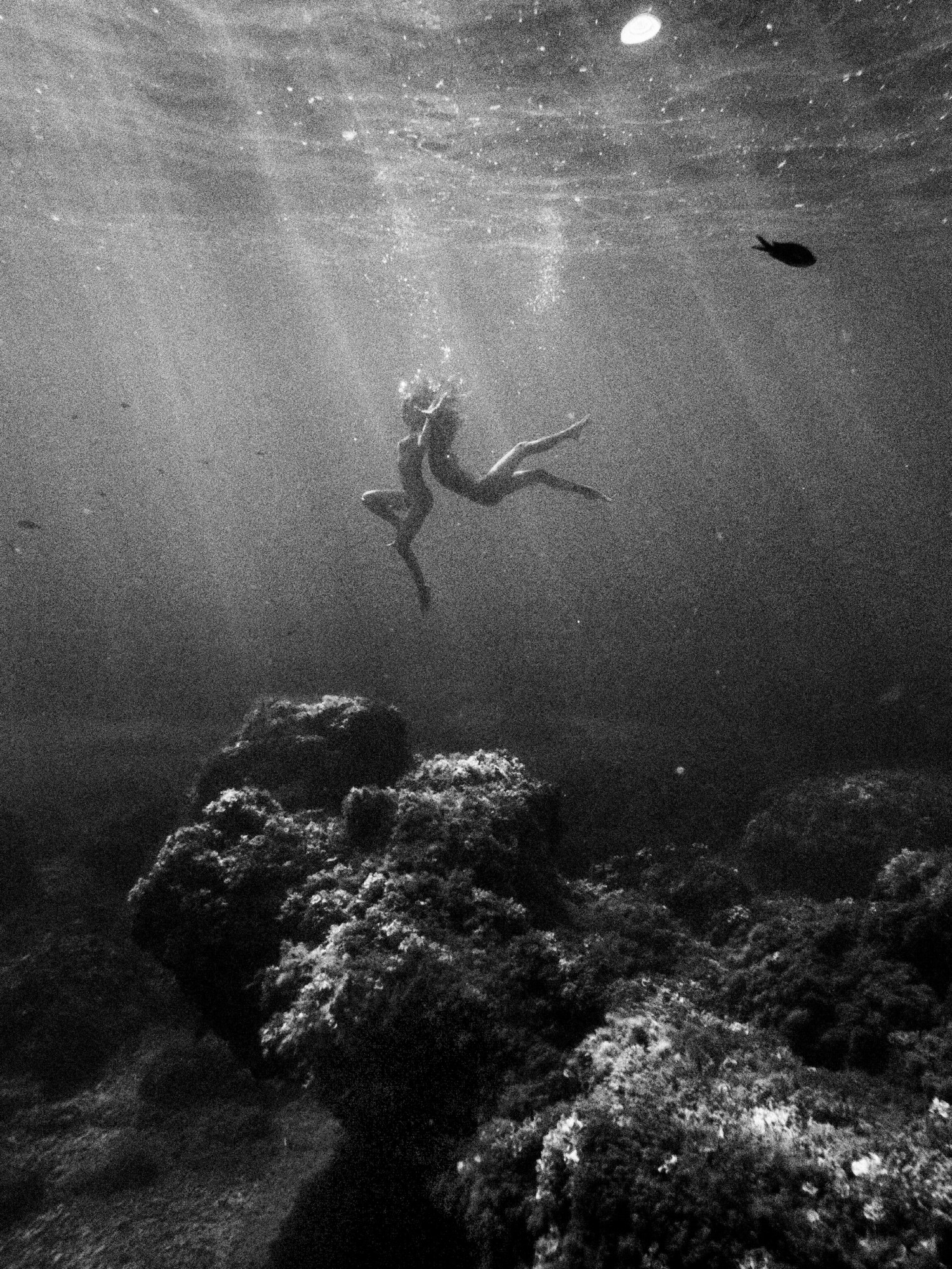 two girls swimming underwater naked and holding hands