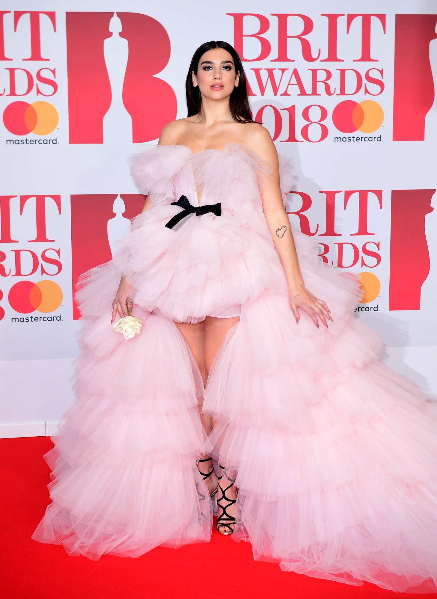 dua lipa posing on the red carpet at the brit awards in a pink tulle dress 2018