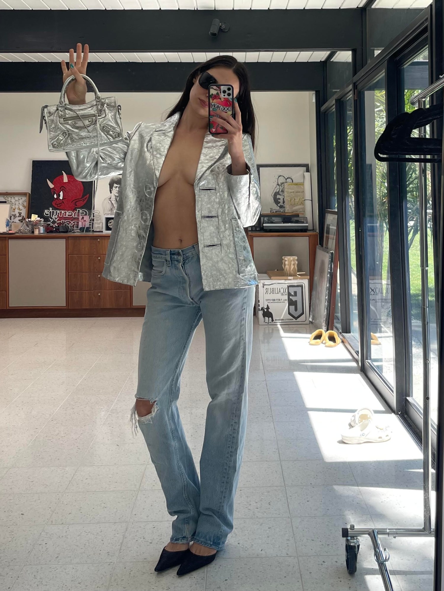 devon lee carlson posing for a mirror selfie in a silver jacket and jeans