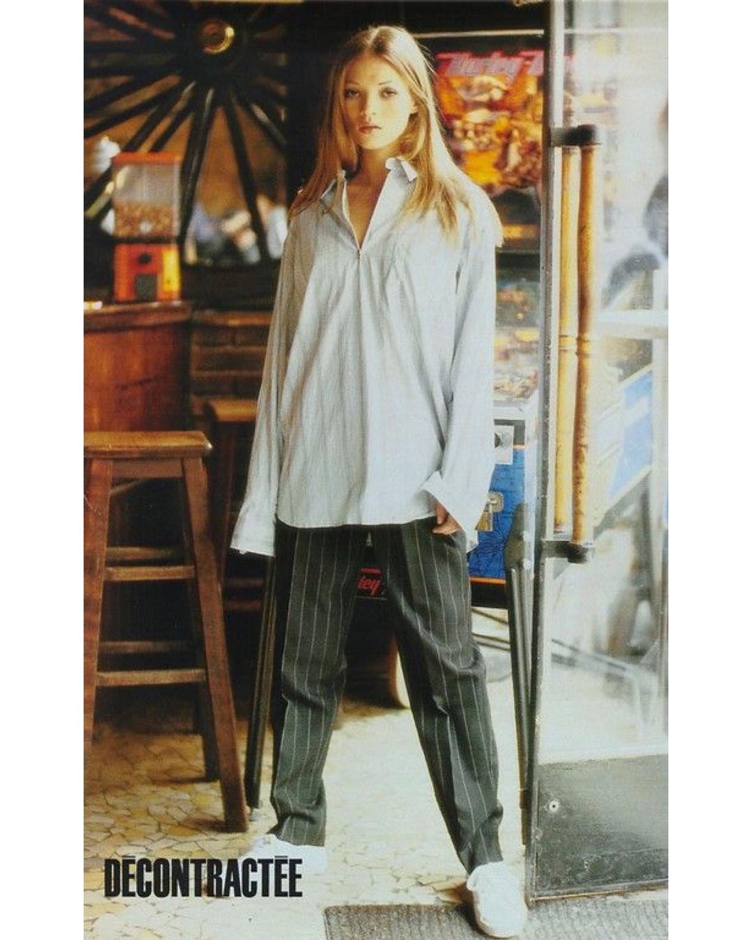 kate moss posing in a button up and trousers for elle france 1992