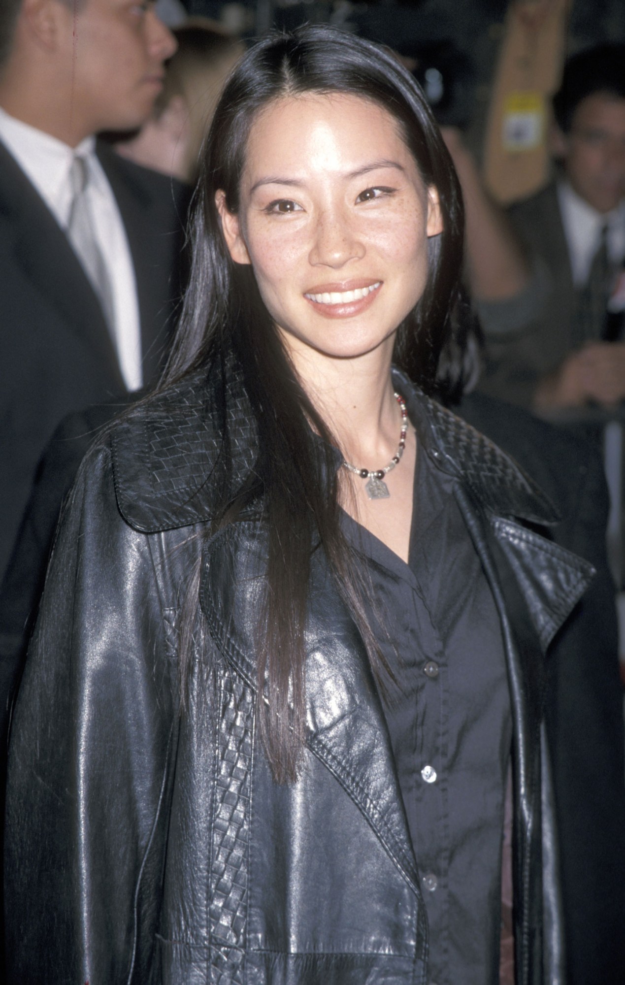 Lucy Liu at a 1999 film premiere wearing an oversized black leather jacket