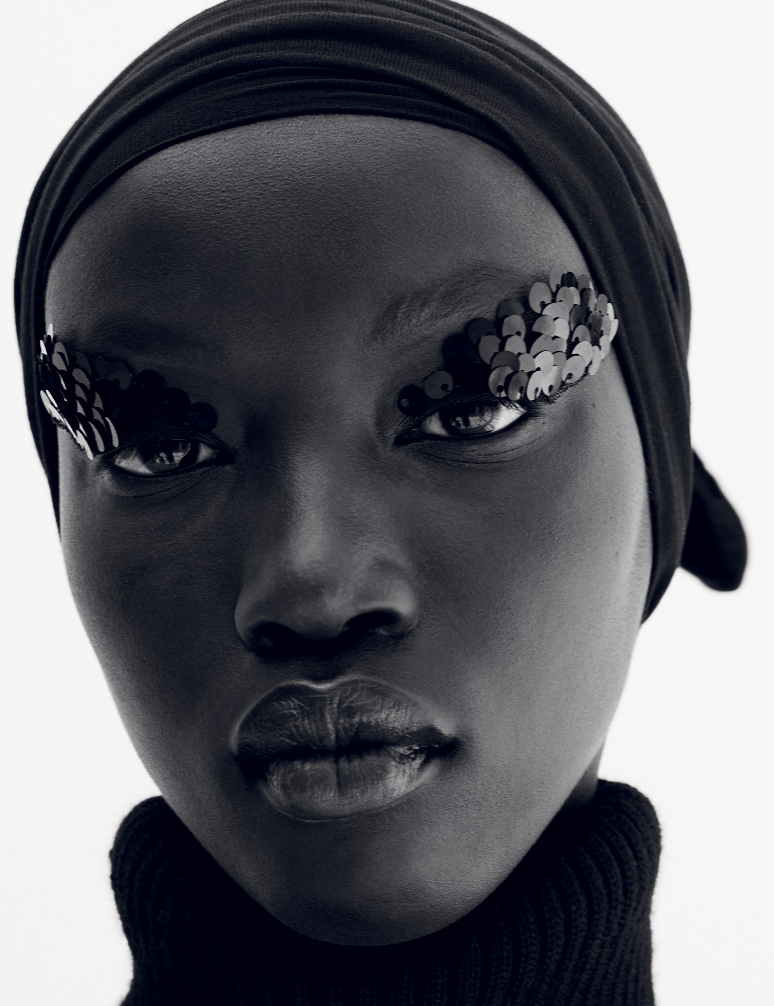 a close up portrait of a model with a sequinned eye beauty look