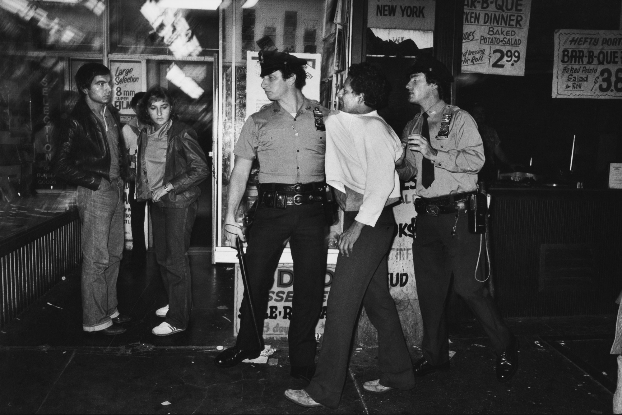 a policeman grabs a man by his jumper