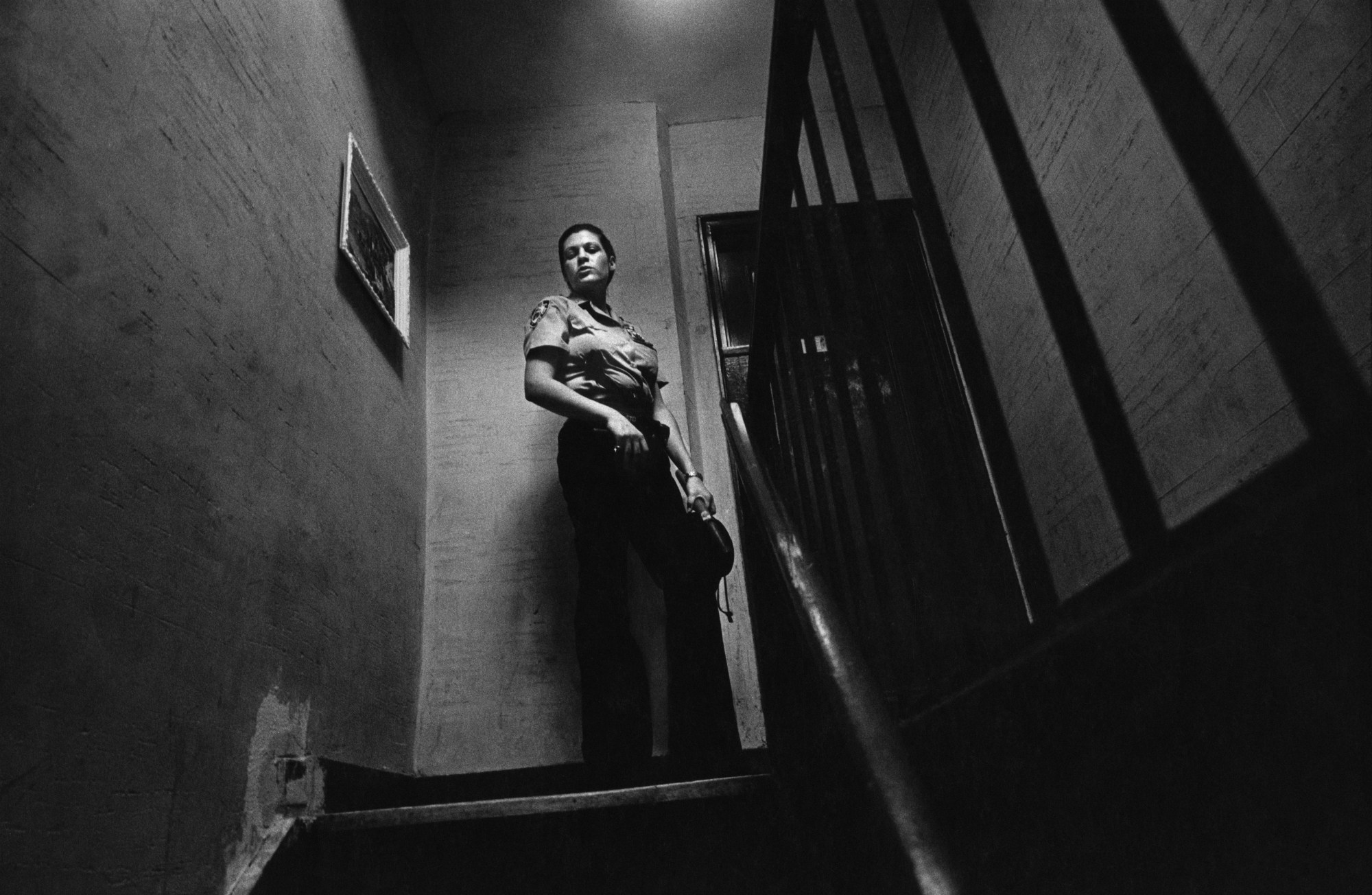 a female police officer looks down the stairs