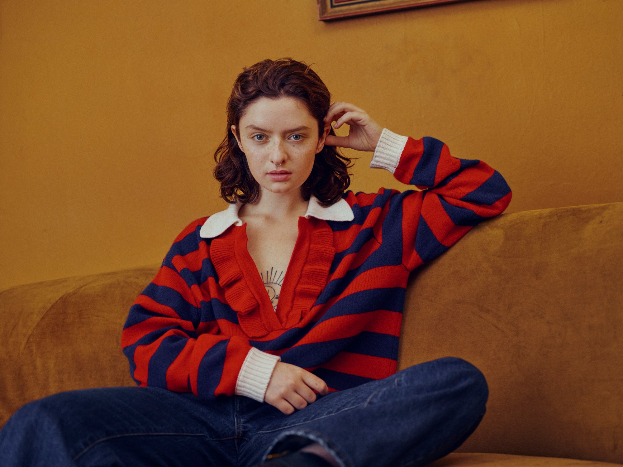 lachlan watson wearing a striped jumper on a sofa in their zalando campaign shot by coco capitan