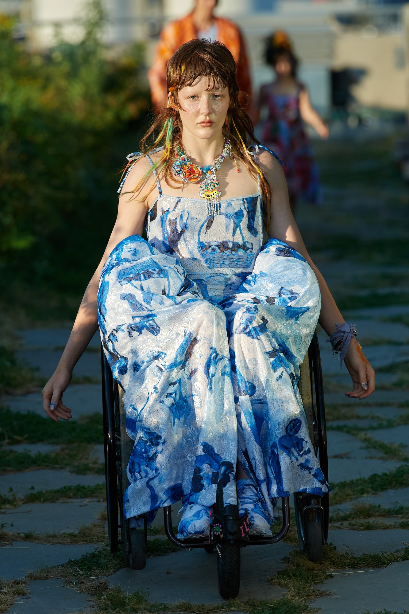 model in a wheelchair on the runway outside wearing collina strada ss22