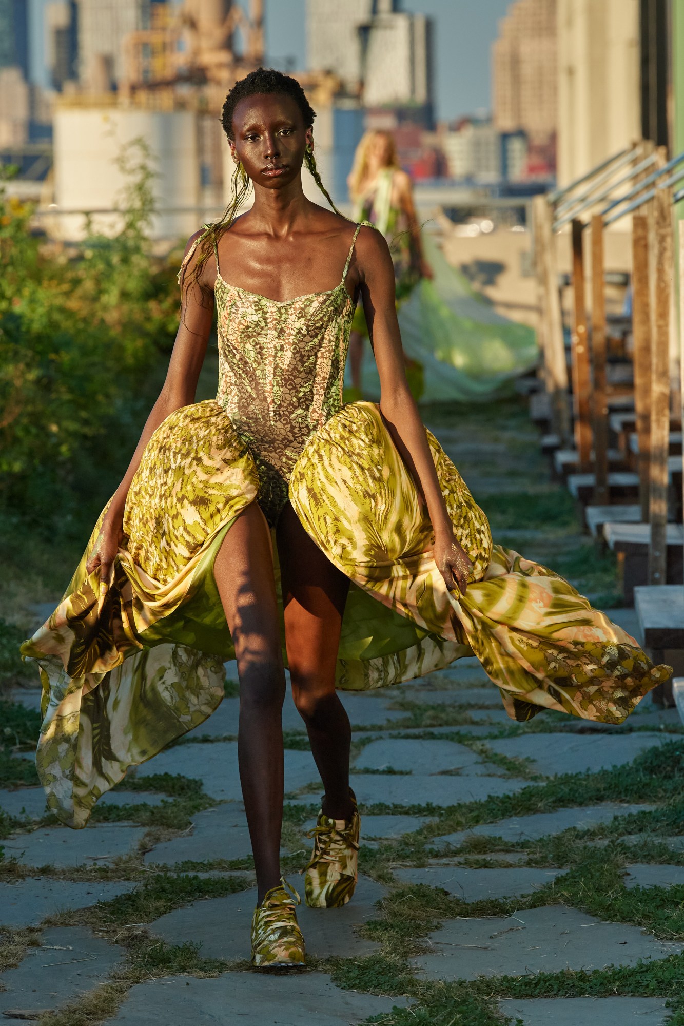 model walking down the runway outside wearing collina strada ss22