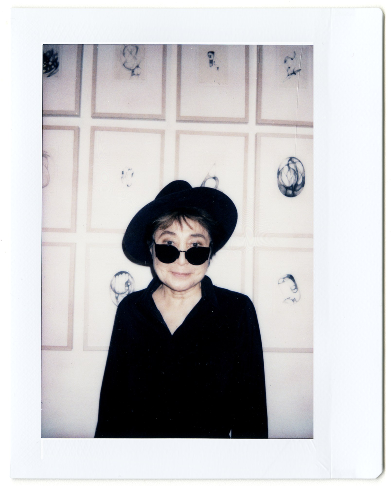 a polaroid of yoko ono in a big hat and sunglasses