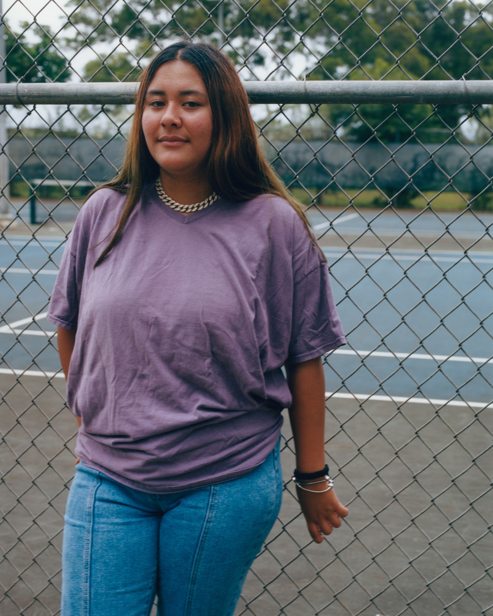 a young woman leans against metal railings