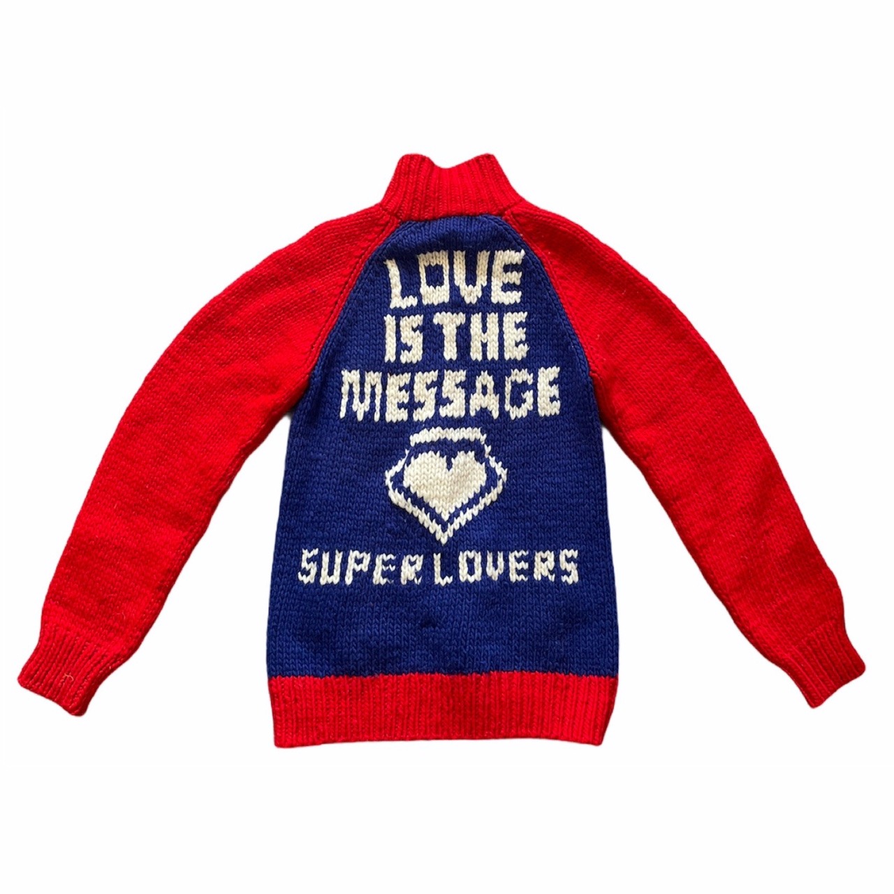 red and blue knitted jumper with the words 'love is the message' on the front