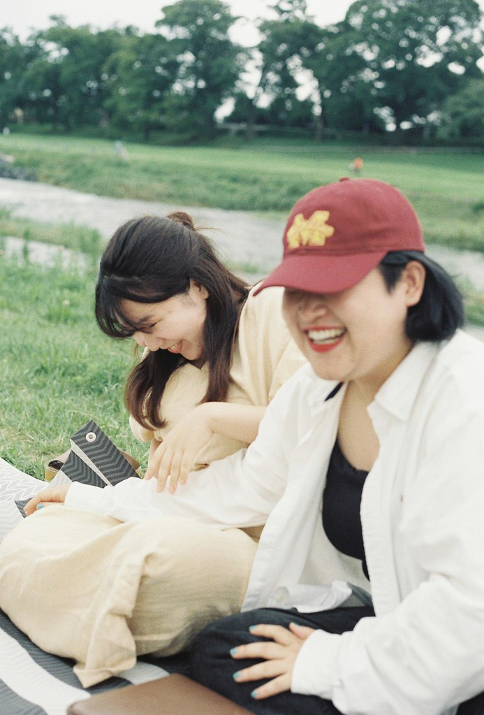 Two friends laugh sitting in the park