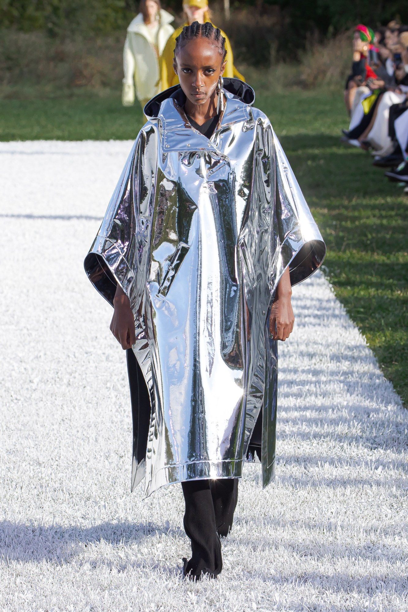 Courreges SS22 catwalk look: a model wears a shiny silver cape