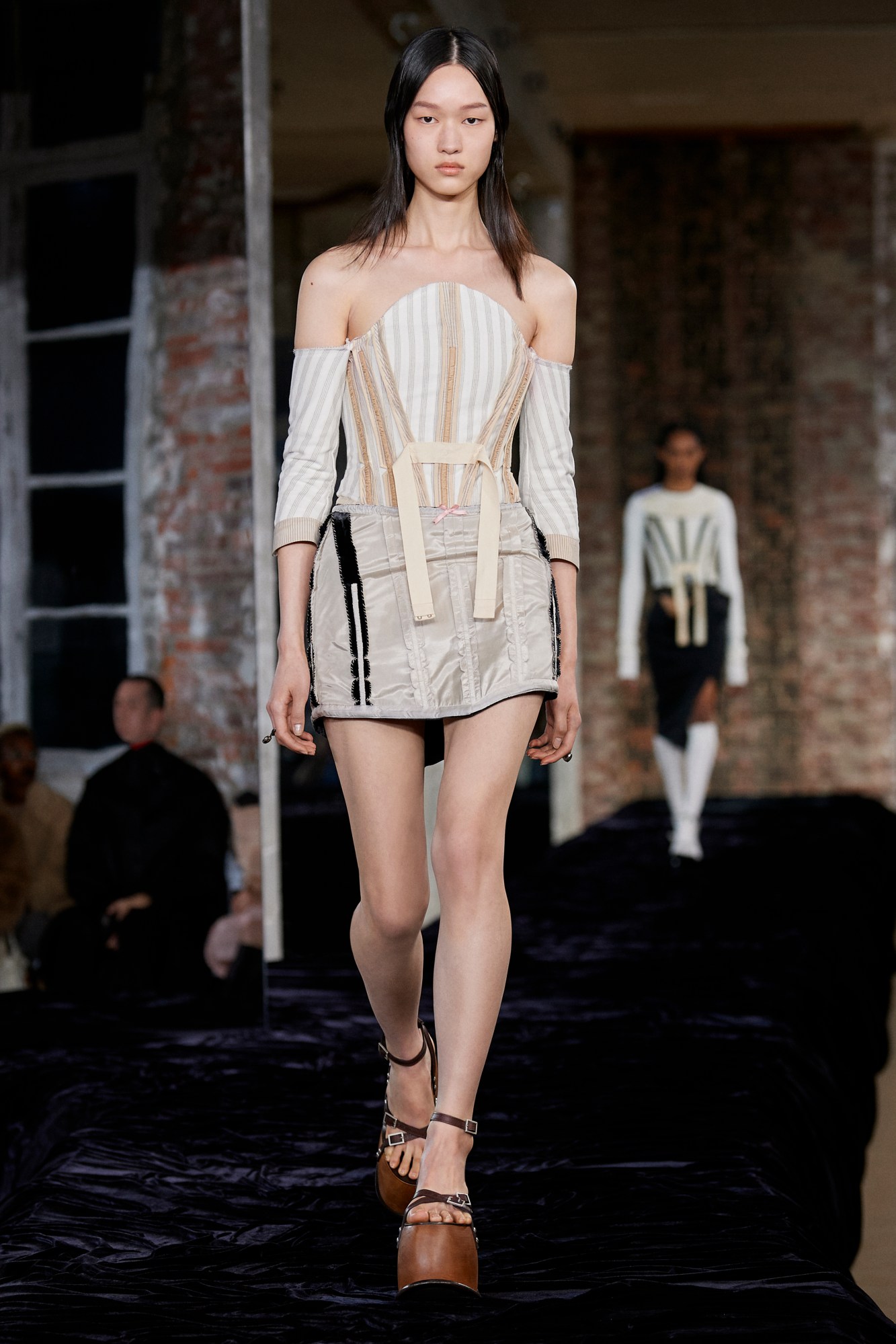 Acne Studios SS22: a model wears a creme-coloured boned bodice and matching mini skirt with chunky wooden heels