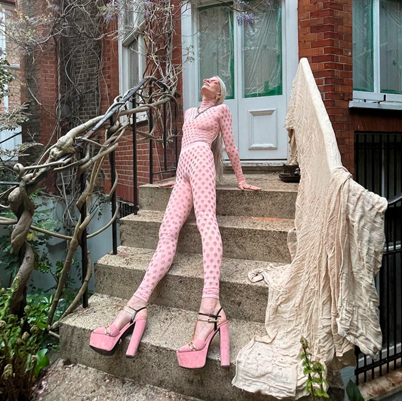 Kristen McMenamy posing on stairs in pink.jpg