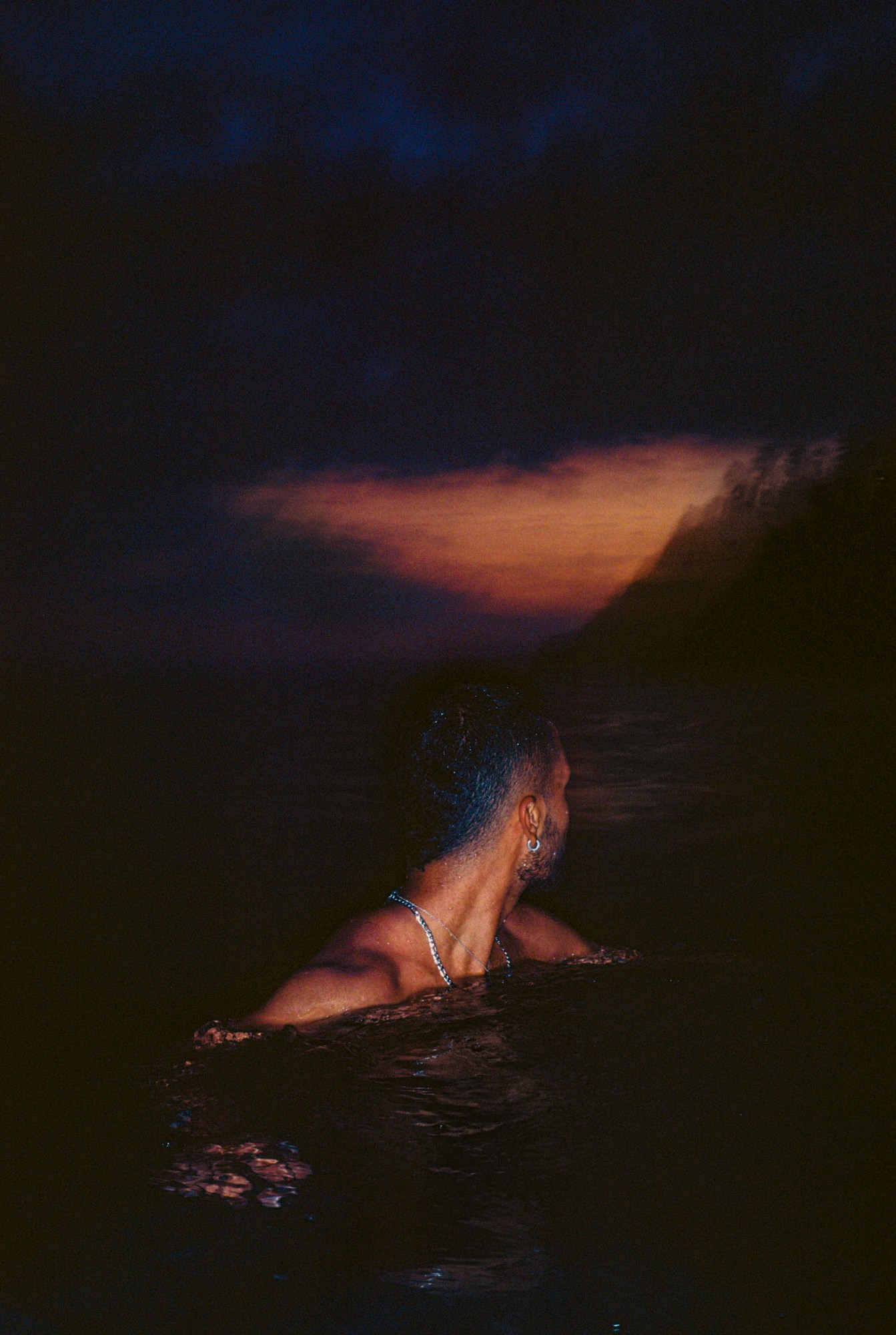 a man swims in the sea in the night