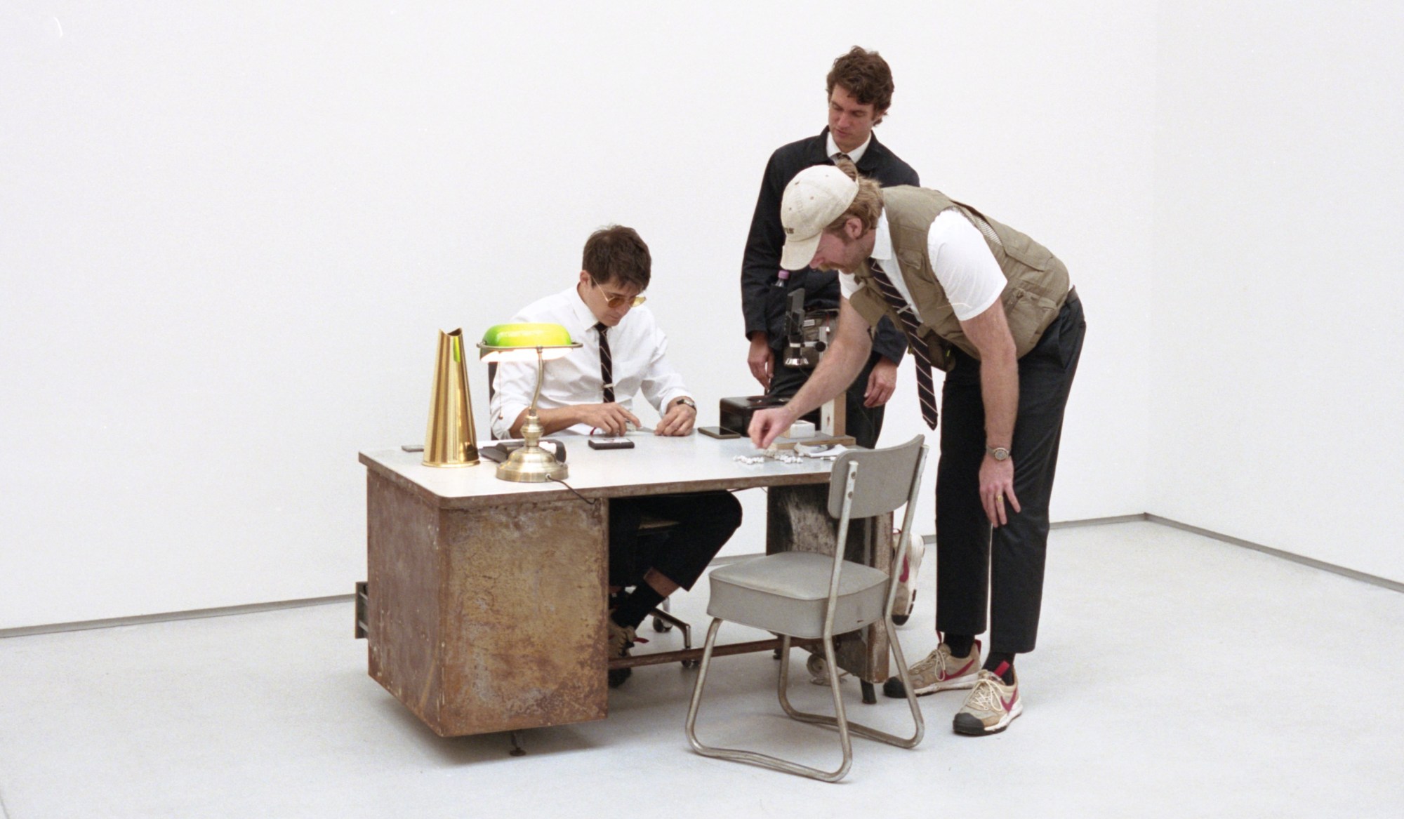 Three men around a desk