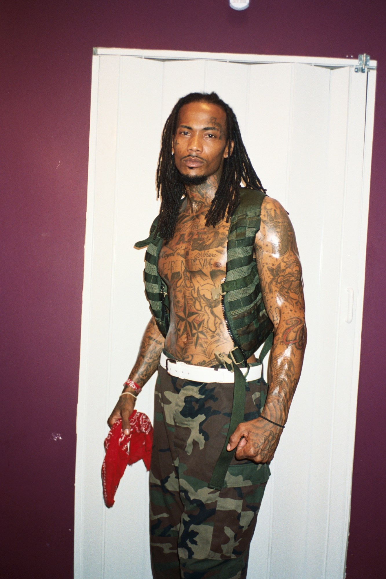 a portrait of a heavily-tattooed man wearing camo