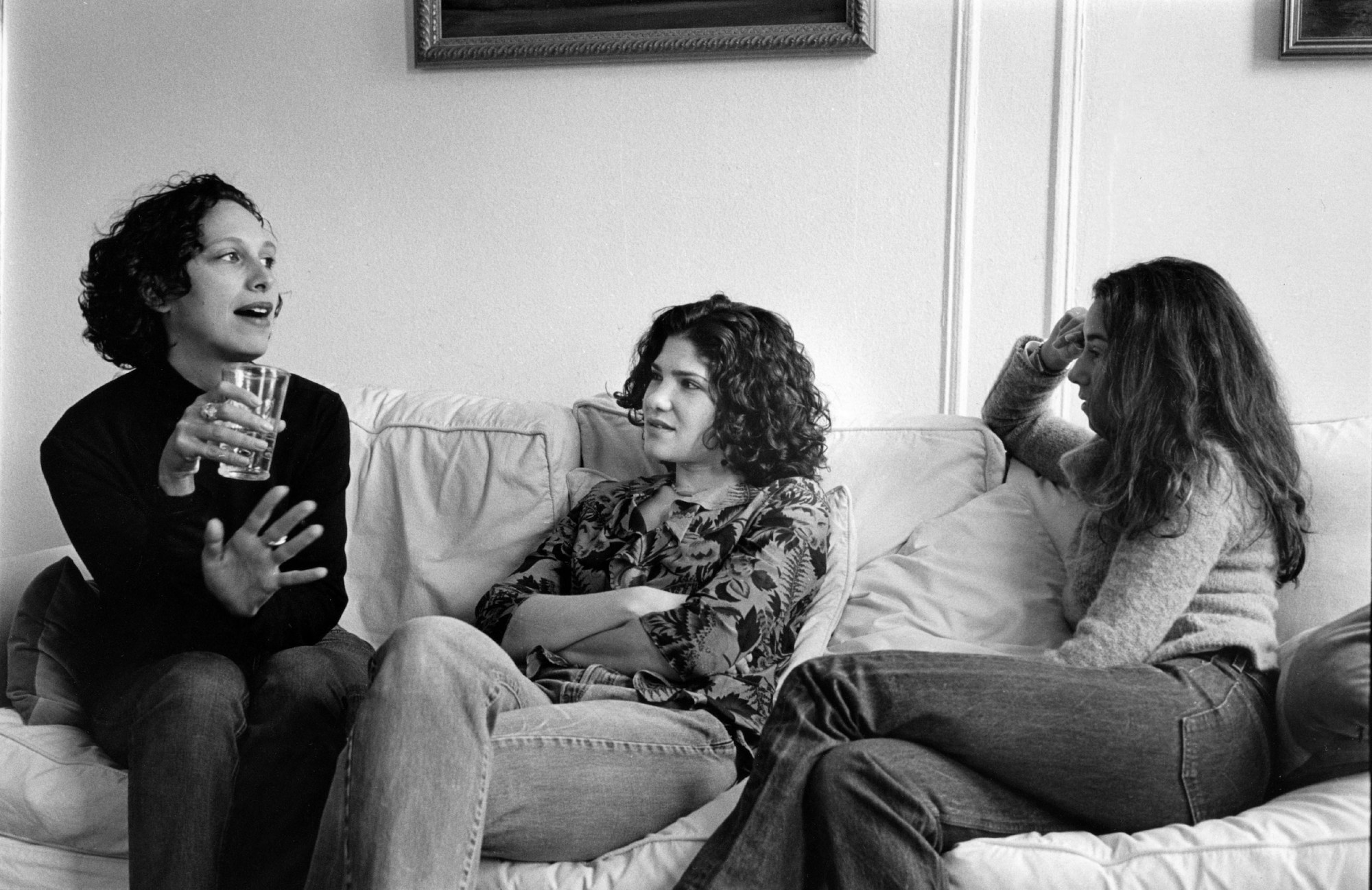 three women sat on a sofa talking