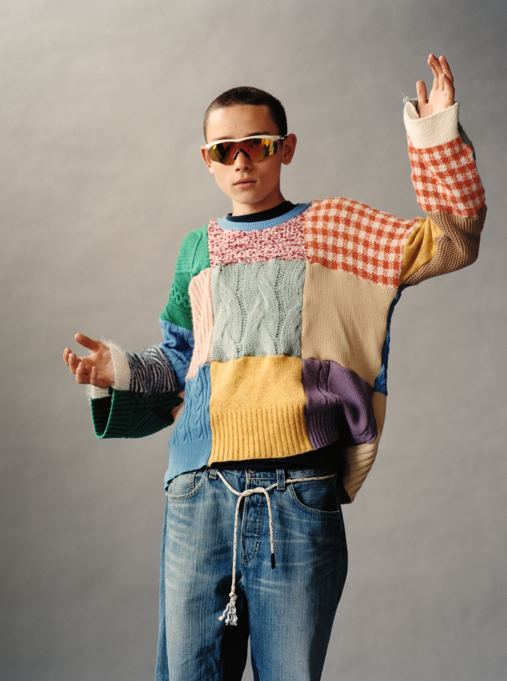 Lola + Pani photograph of a young model wearing a patchwork jumper, jeans and reflective sunglasses