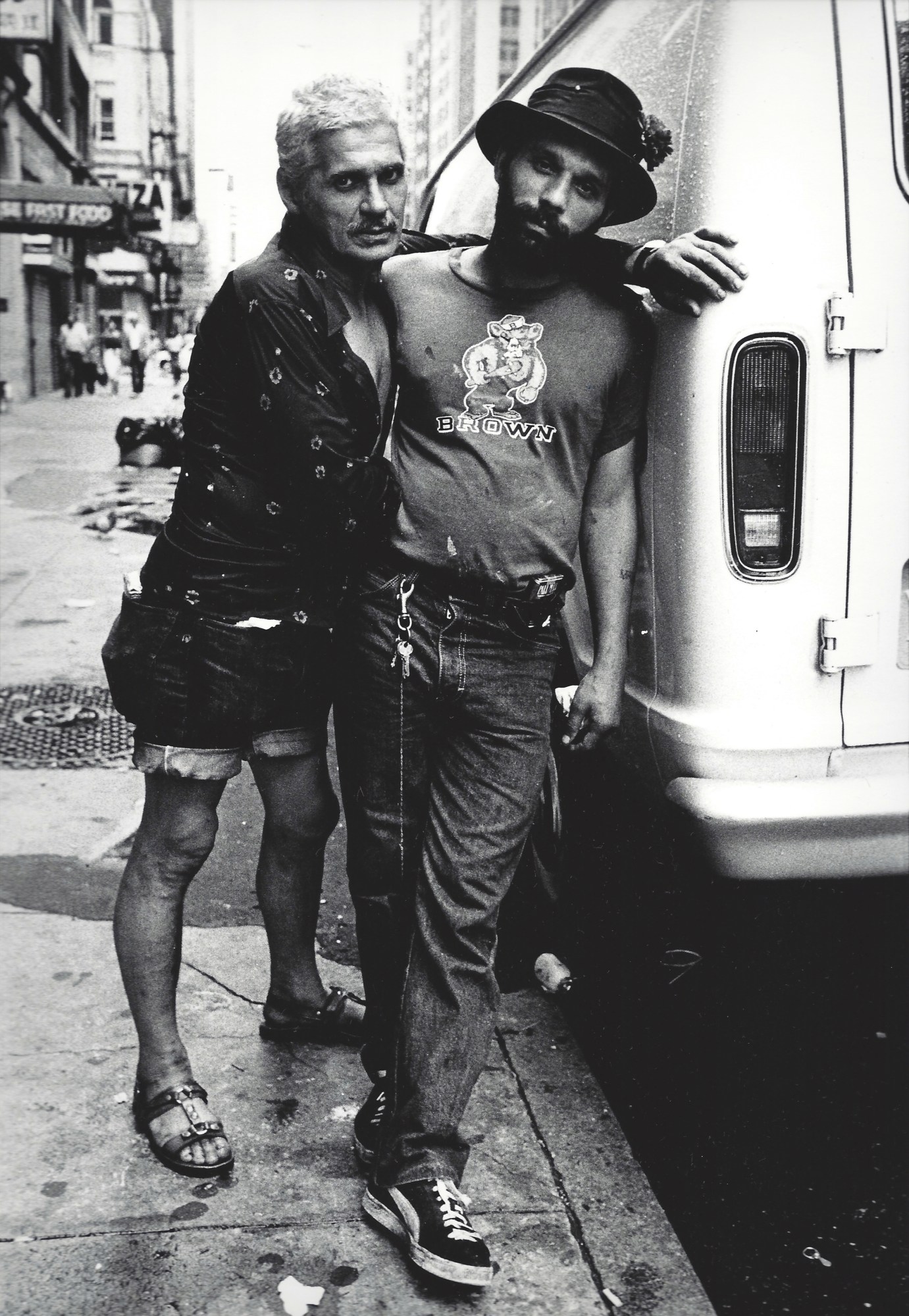 two men leaning on one another on the street in new york