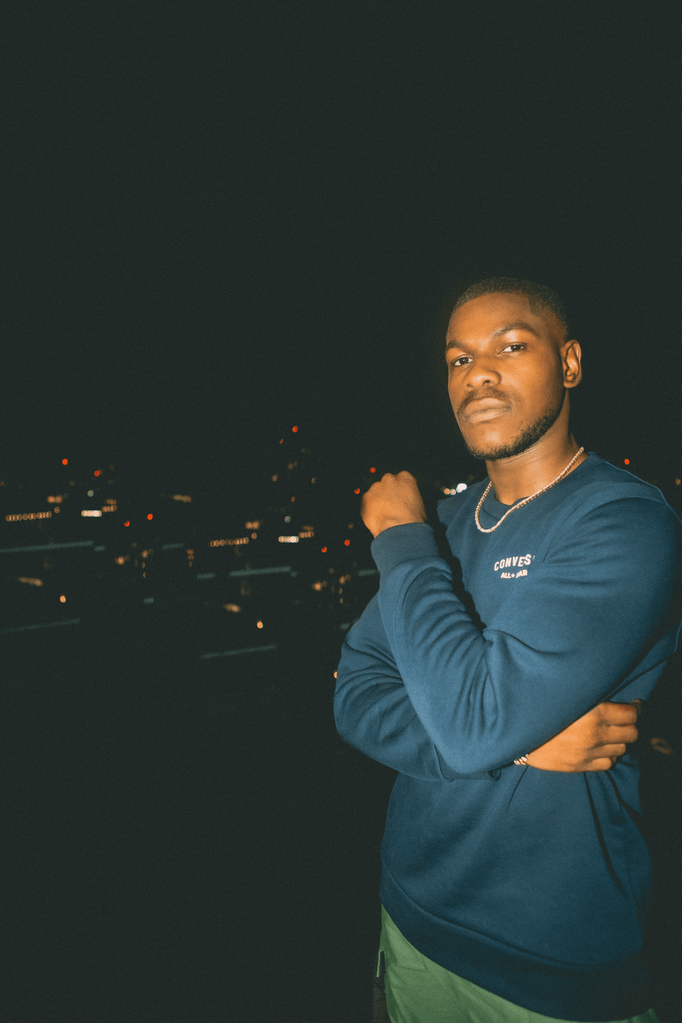 John Boyega on rooftop with night time cityscape background